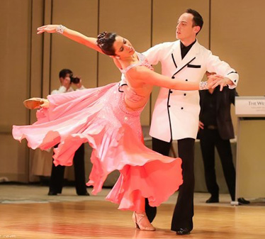 Nicole competes wearing a flowing pink dress