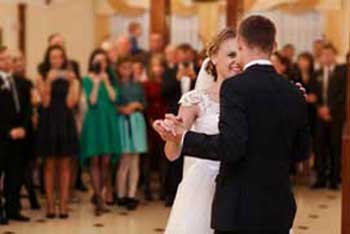 Newlyweds dance together in front of wedding guests